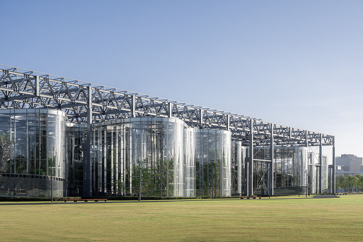 The former steelworks of a power plant are integrated with organically-shaped greenhouse pavilions
