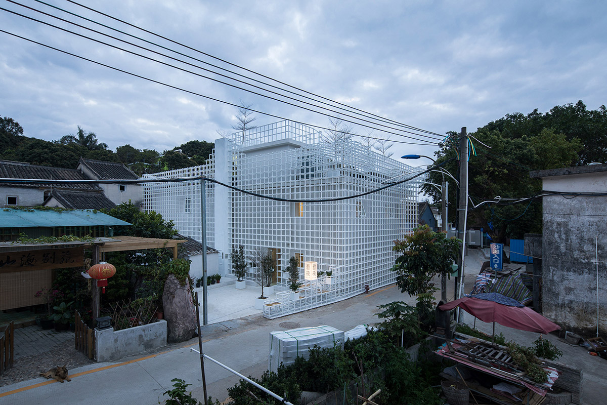 Aether Architects converted old village house into a local hostel by wrapping with structural lattice