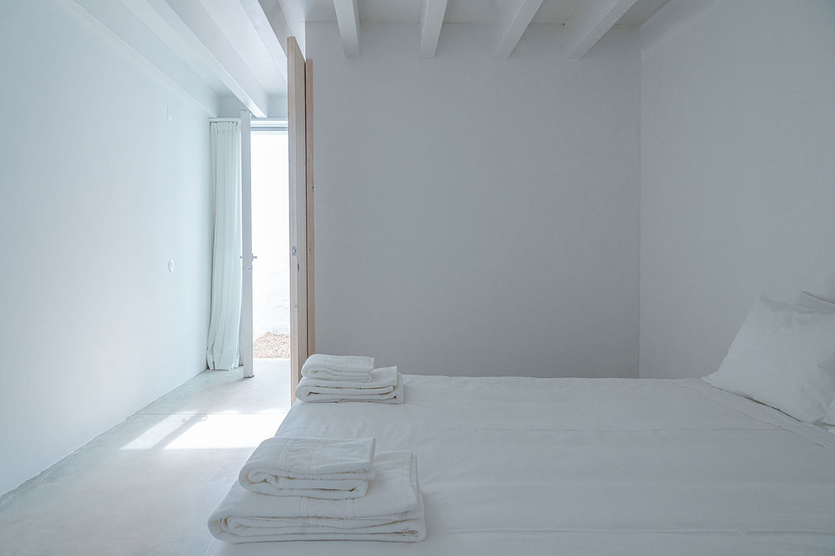 Low-profiled whitewashed stone walls wrap living units of Casa da Volta by PROMONTORIO and João Cravo