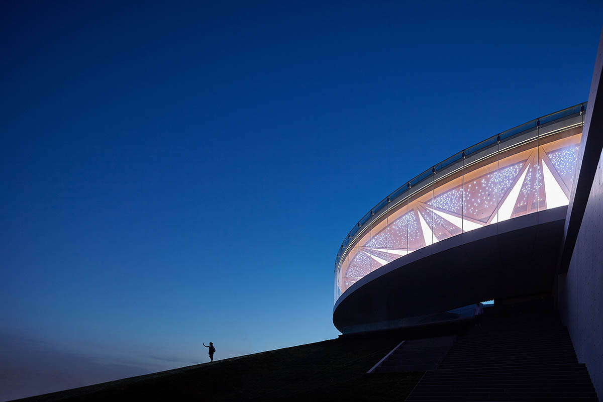 STUDIO A+ designs climbable ring-shaped art center on a green mound in Zhengzhou