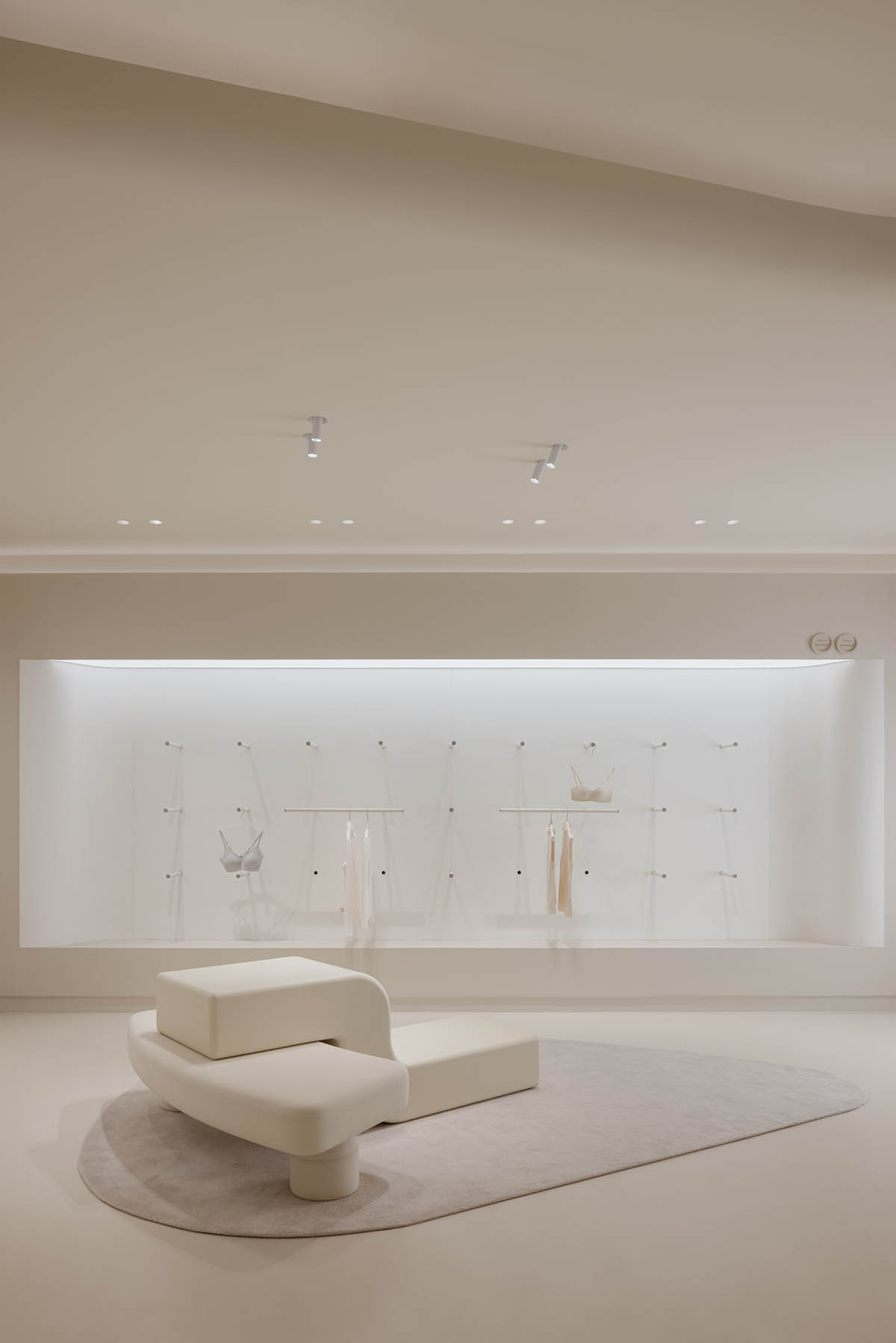 Store interiors by Sò Studio features soft beige tones to give the feeling of 