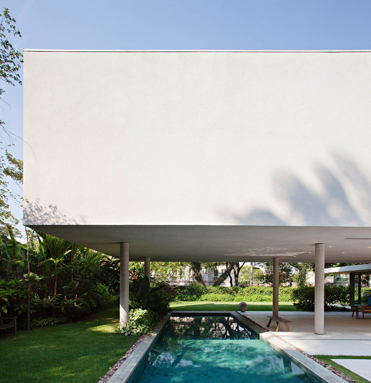 Perkins+Will's Cidade Jardim House features a large garden space under thin columns