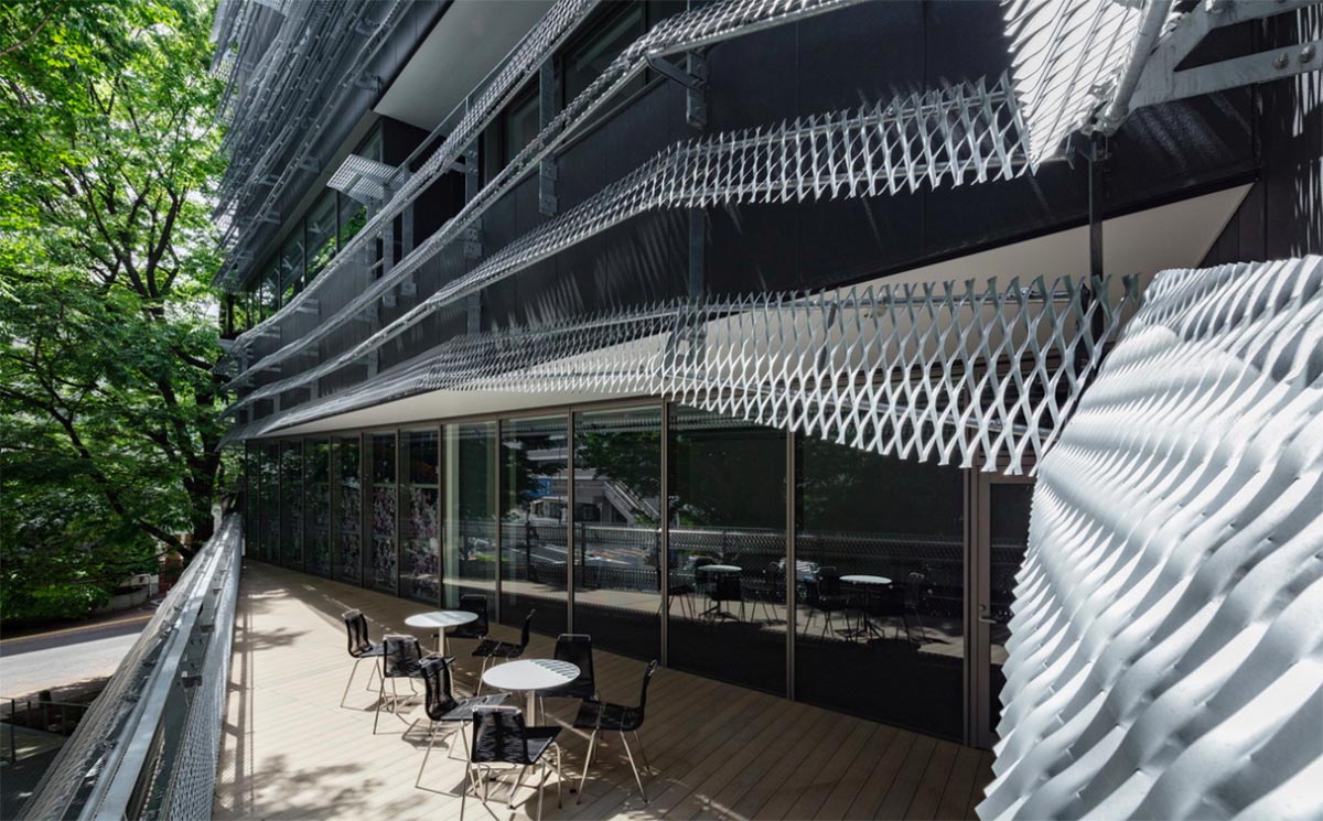 Kengo Kuma wraps alumni building in Tokyo with irregular metal surface creating organic skin
