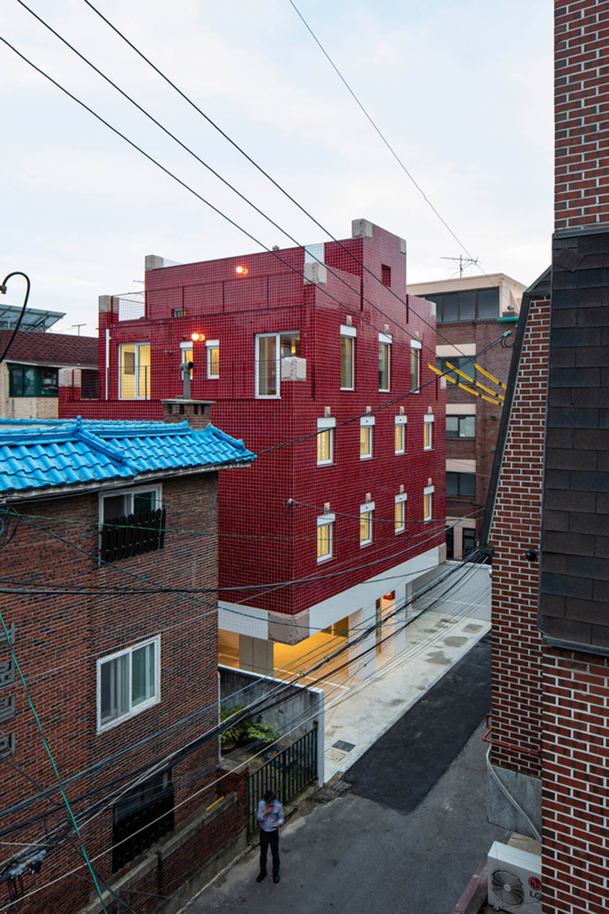 aoa architects uses red marble tiles to clad this apartment in South Korean neighborhood