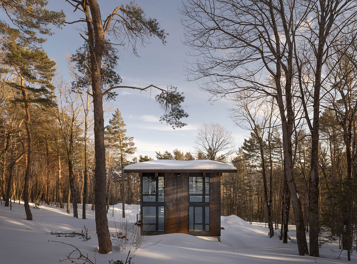 Olson Kundig creates compact and minimal family cabin in a heavily wooded landscape in Vermont