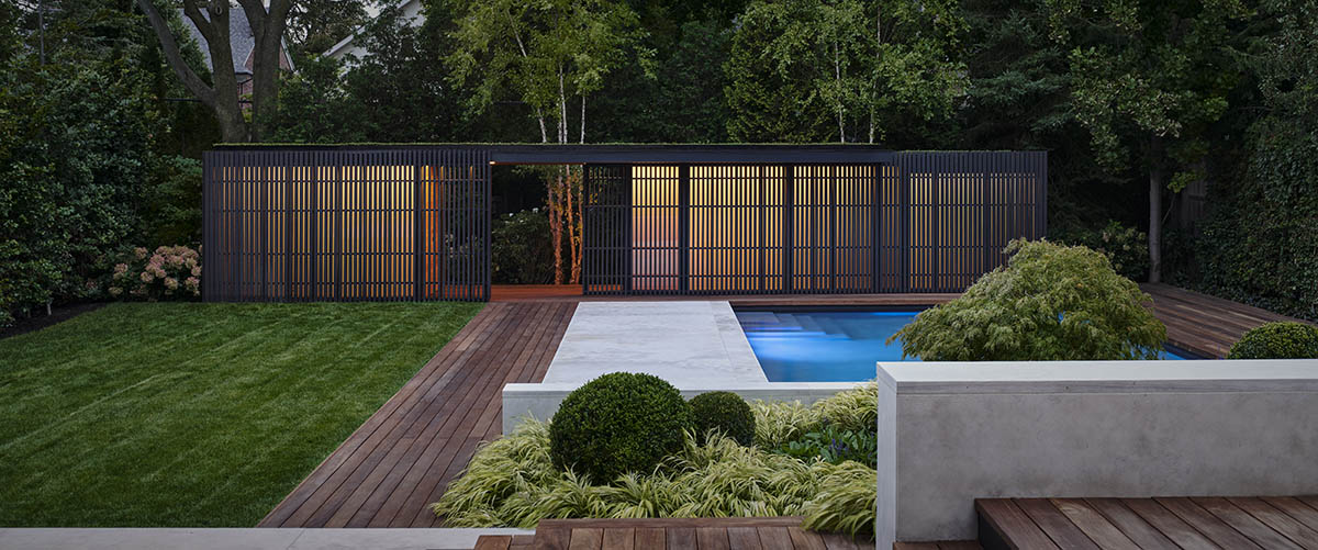 Vertical cedar battens wrap this pavilion by Amantea Architects in a lush green landscape in Toronto