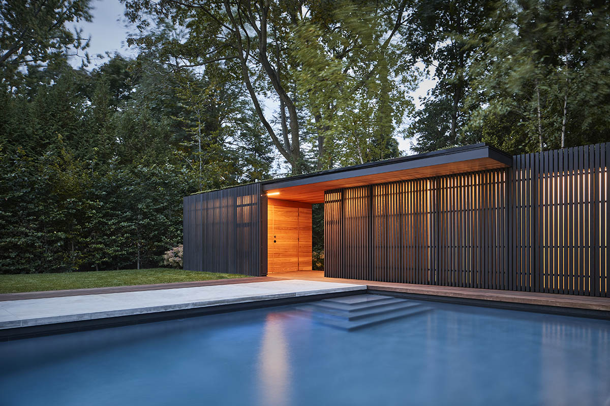 Vertical cedar battens wrap this pavilion by Amantea Architects in a lush green landscape in Toronto
