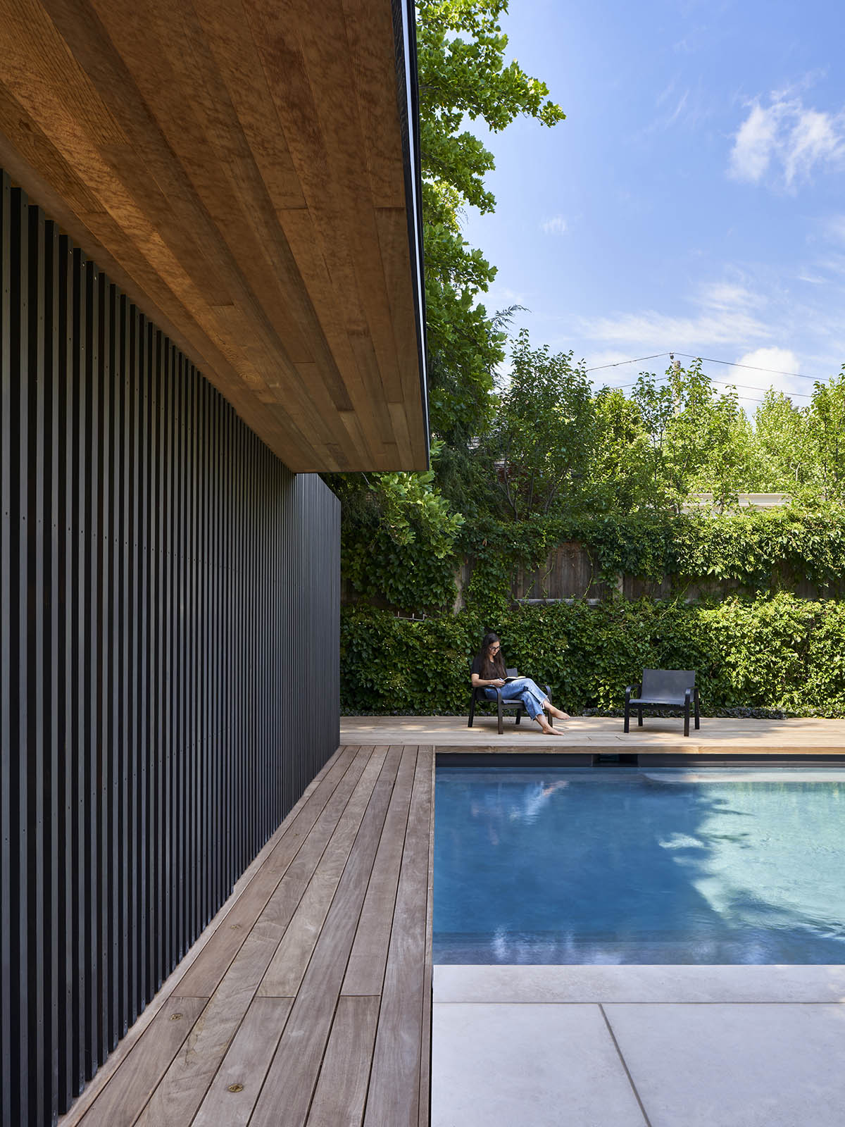 Vertical cedar battens wrap this pavilion by Amantea Architects in a lush green landscape in Toronto