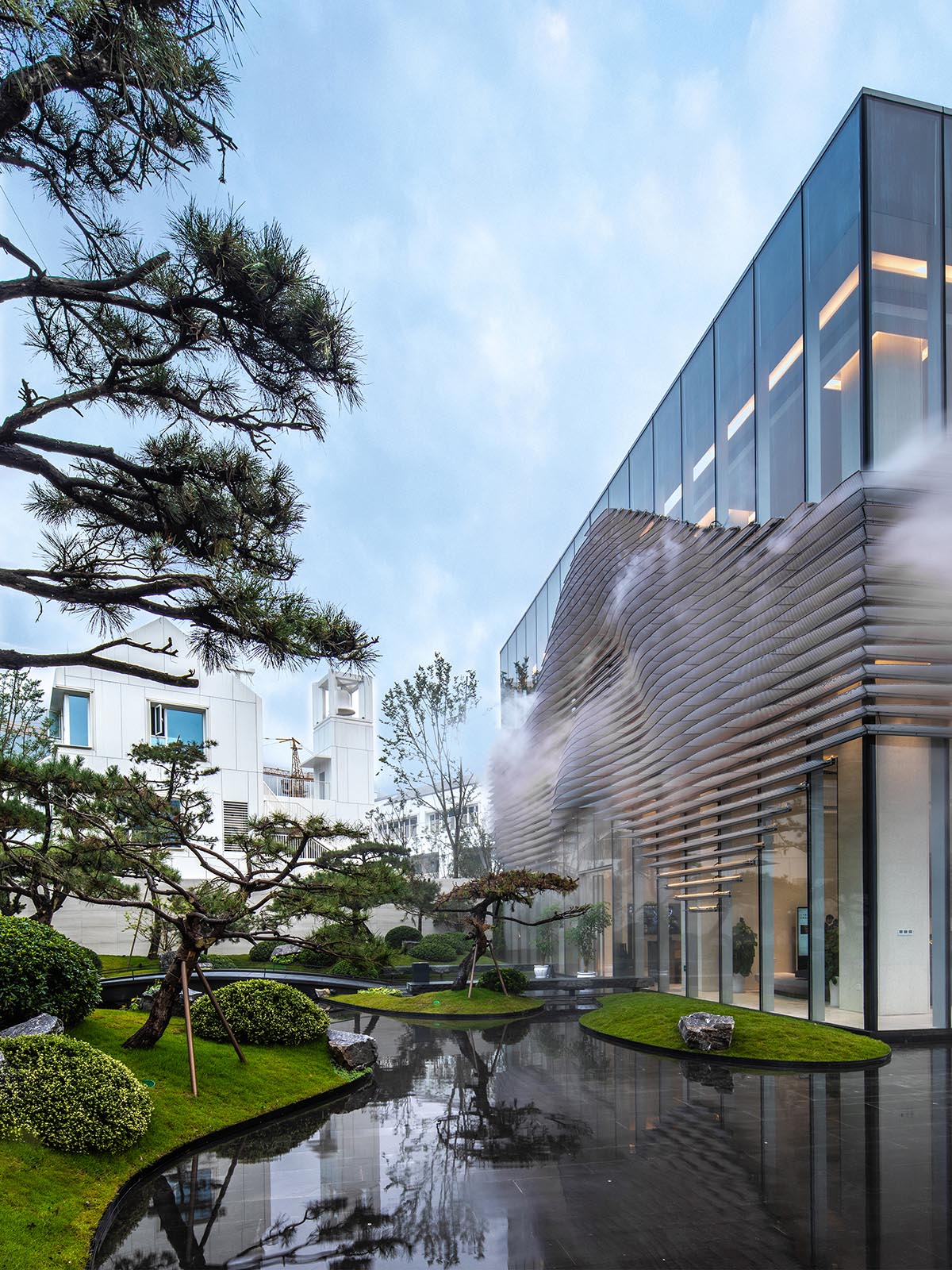 aoe wraps this sales pavilion with perforated plates that create a long scroll landscape painting