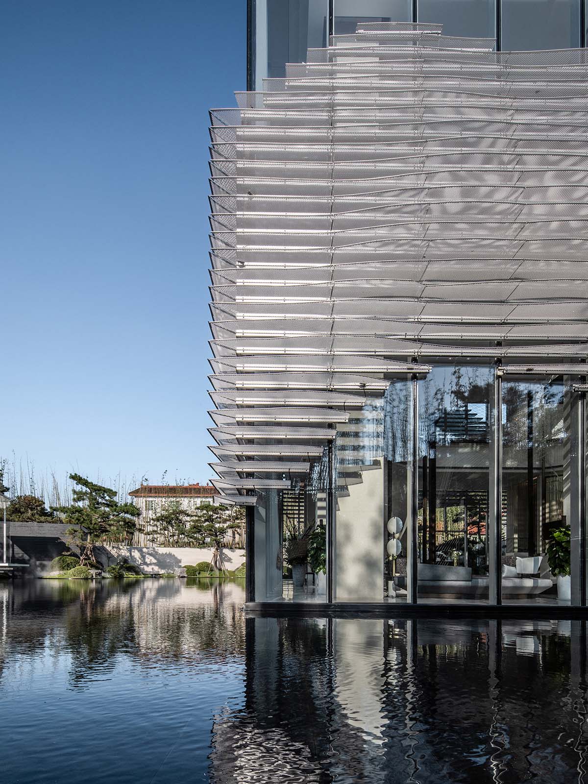 aoe wraps this sales pavilion with perforated plates that create a long scroll landscape painting