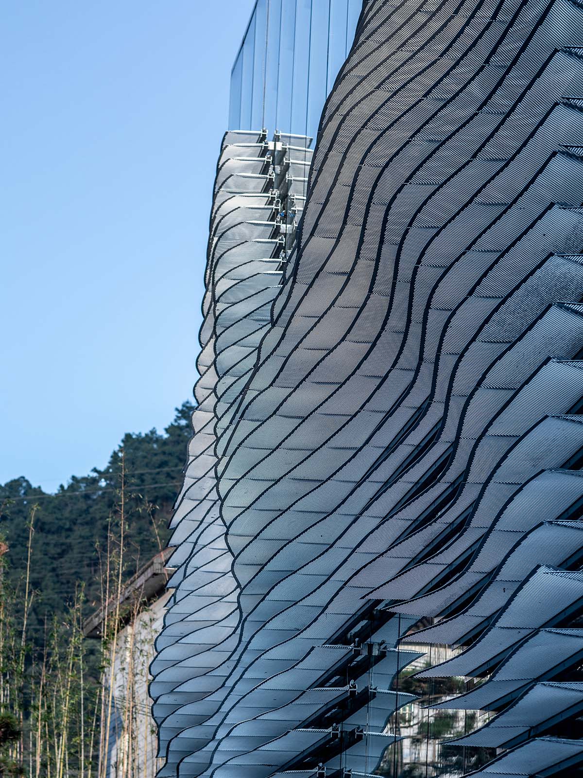 aoe wraps this sales pavilion with perforated plates that create a long scroll landscape painting