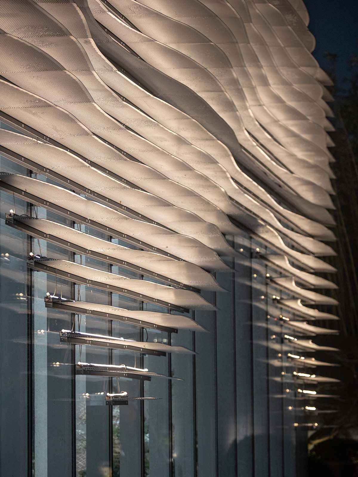 aoe wraps this sales pavilion with perforated plates that create a long scroll landscape painting