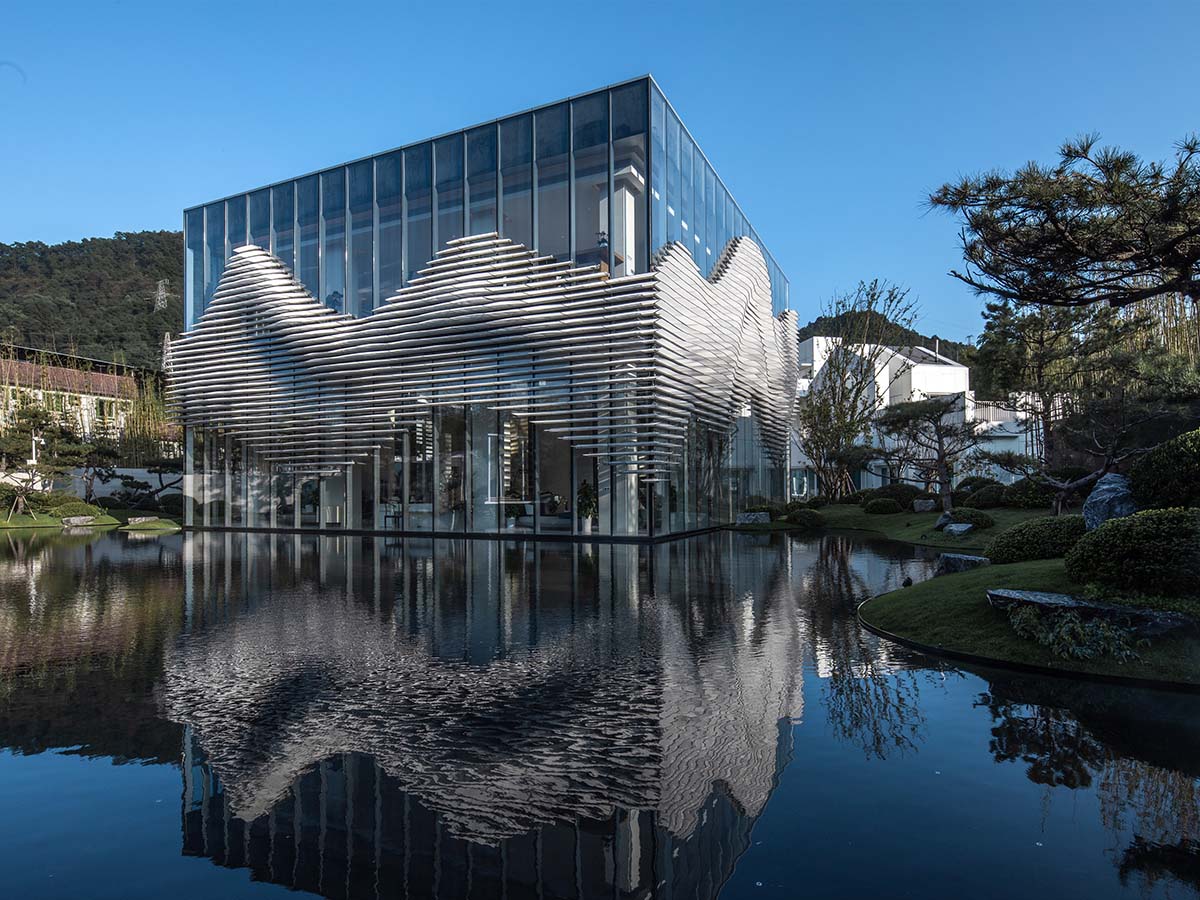 aoe wraps this sales pavilion with perforated plates that create a long scroll landscape painting