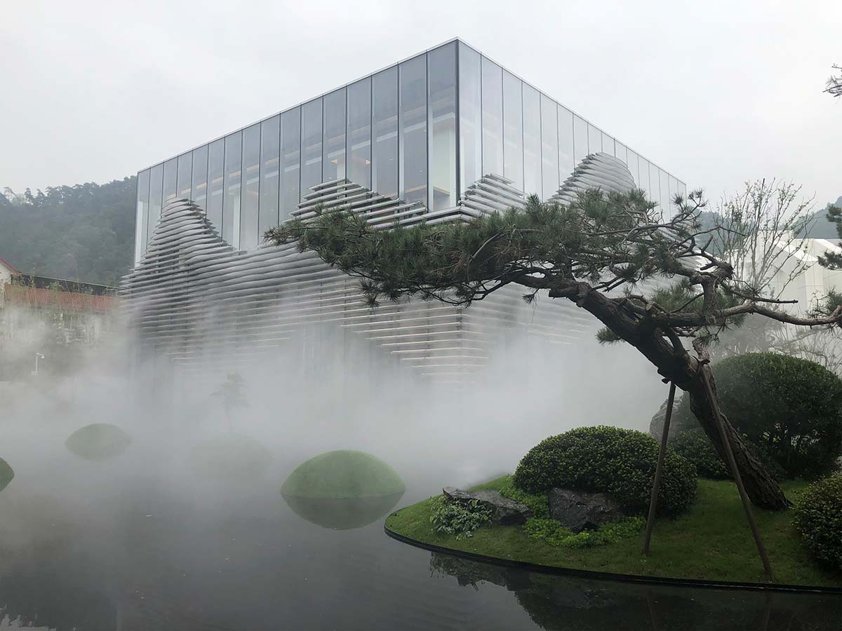 aoe wraps this sales pavilion with perforated plates that create a long scroll landscape painting