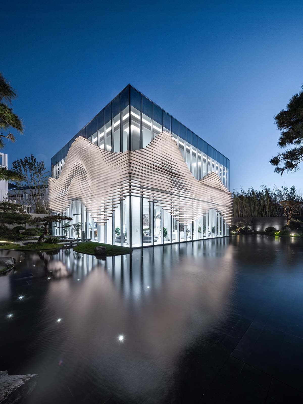 aoe wraps this sales pavilion with perforated plates that create a long scroll landscape painting