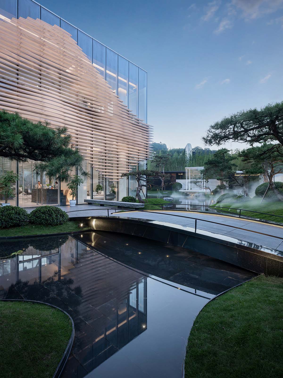 aoe wraps this sales pavilion with perforated plates that create a long scroll landscape painting