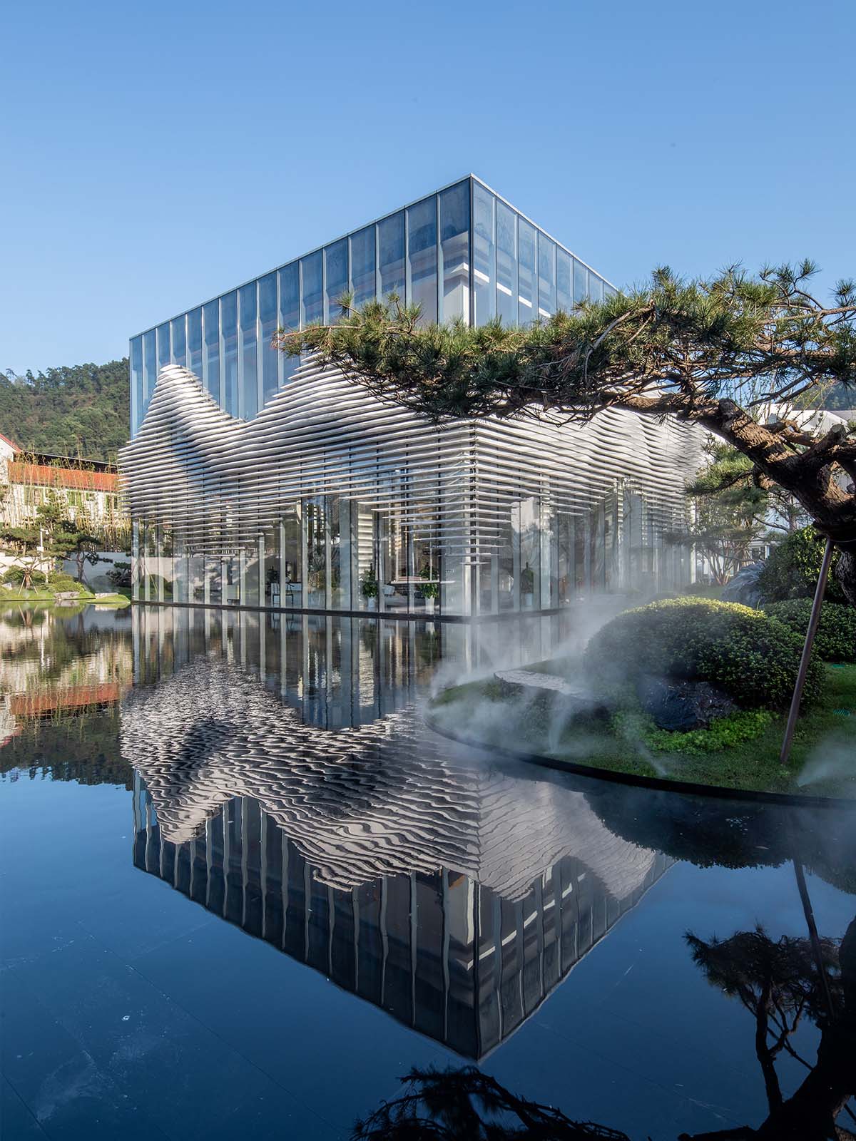 aoe wraps this sales pavilion with perforated plates that create a long scroll landscape painting