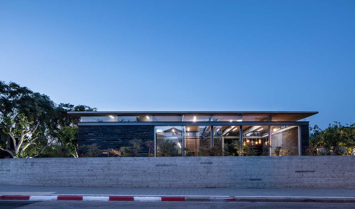 Pitsou Kedem Architects' black Pavilion House is reflected onto a linear swimming pool in Israel