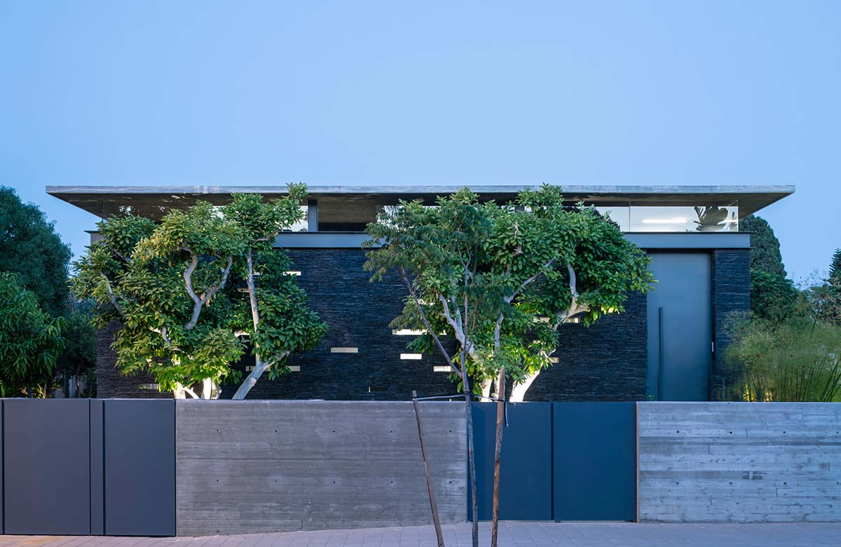 Pitsou Kedem Architects' black Pavilion House is reflected onto a linear swimming pool in Israel