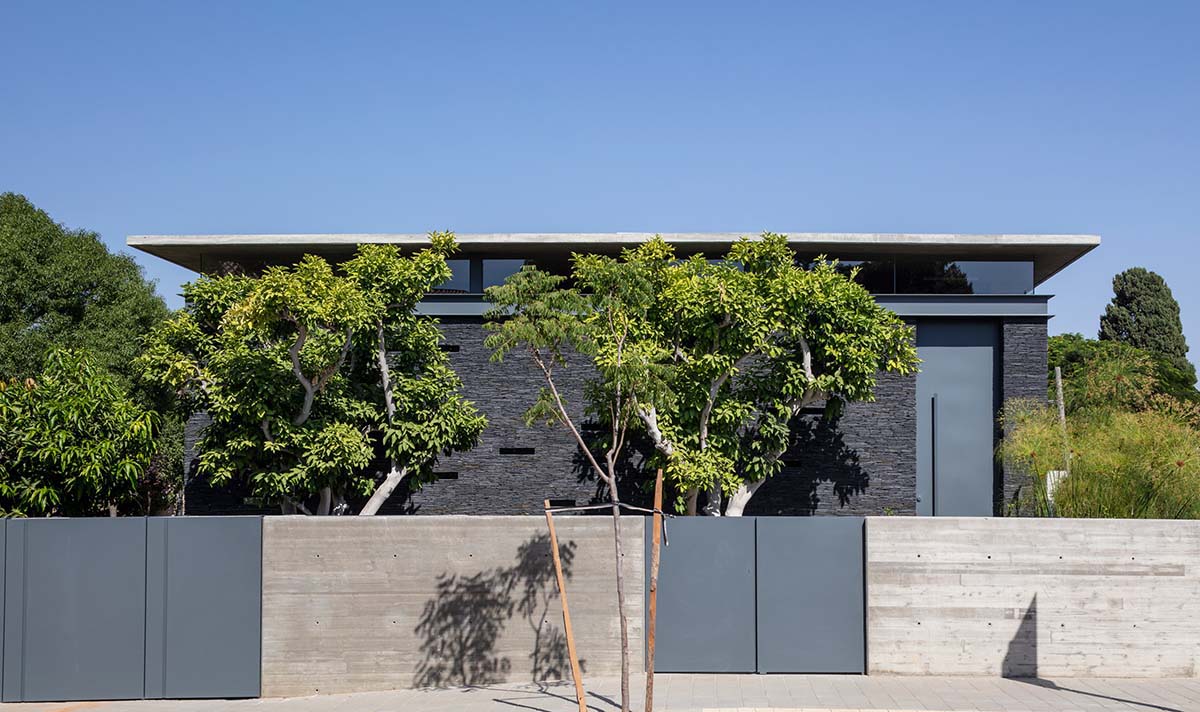Pitsou Kedem Architects' black Pavilion House is reflected onto a linear swimming pool in Israel