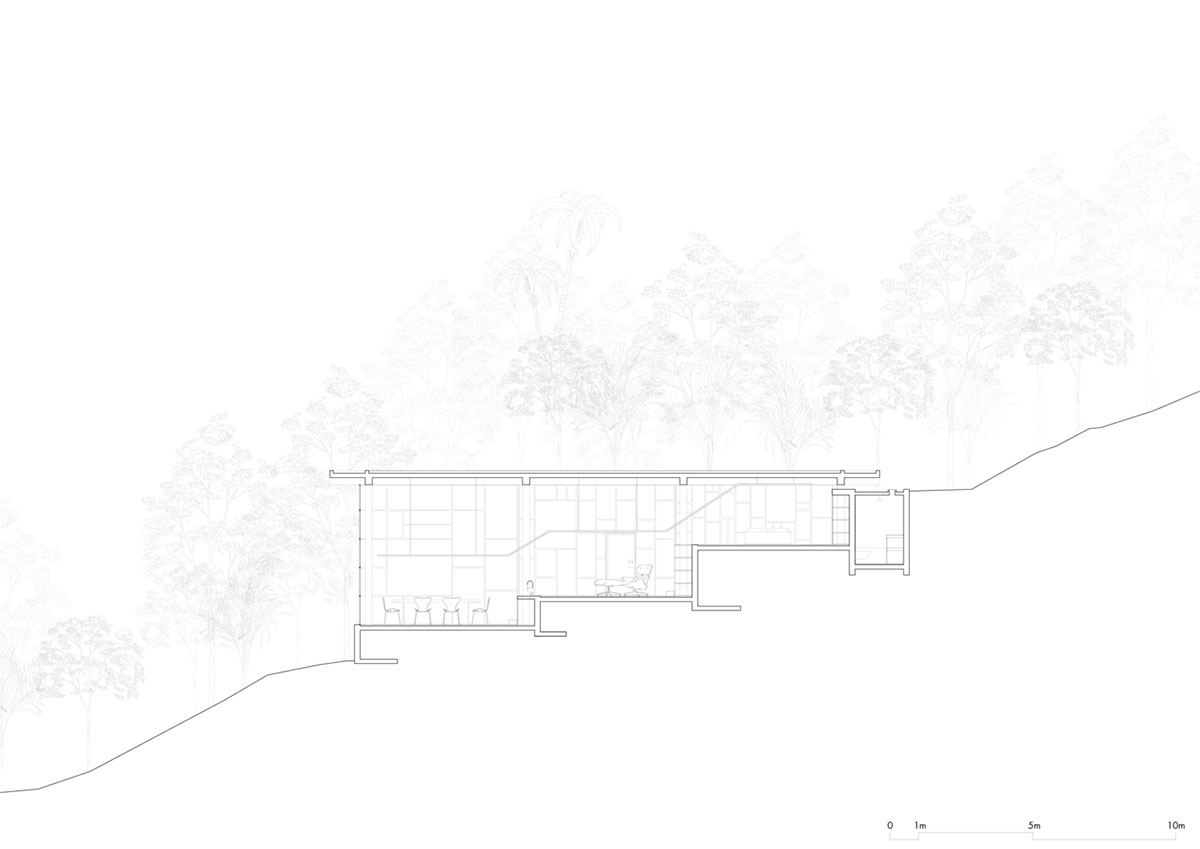 Two bold concrete platforms define this transparent library house by Atelier Branco Arquitetura