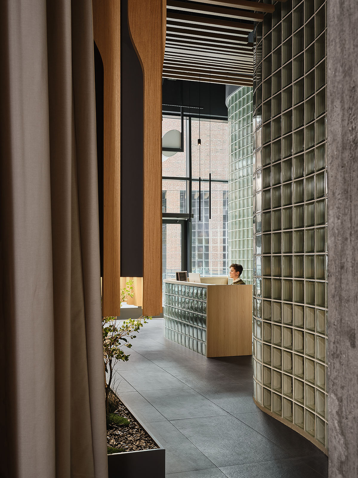 Eye care clinic features a sweeping glass block wall to disperse light in the interior