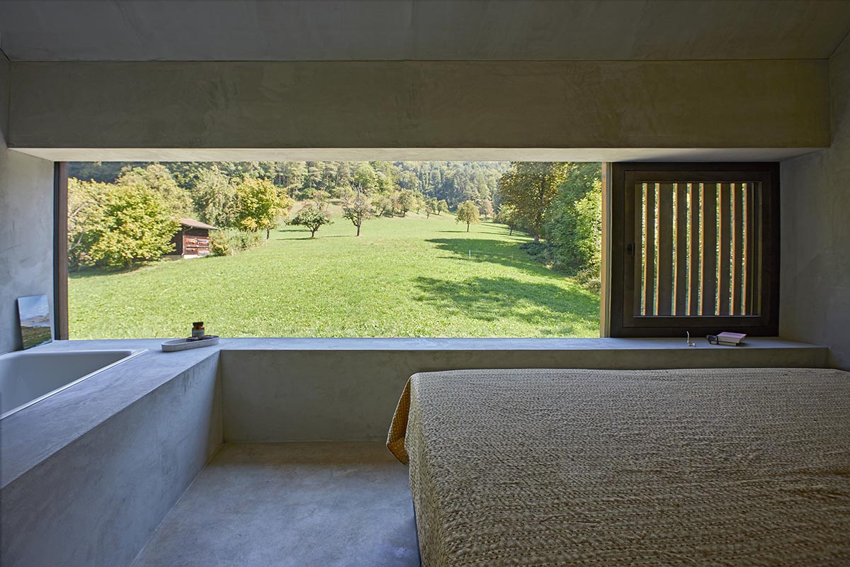 Residential barn features an unfinished, raw interior in Swiss rural landscape