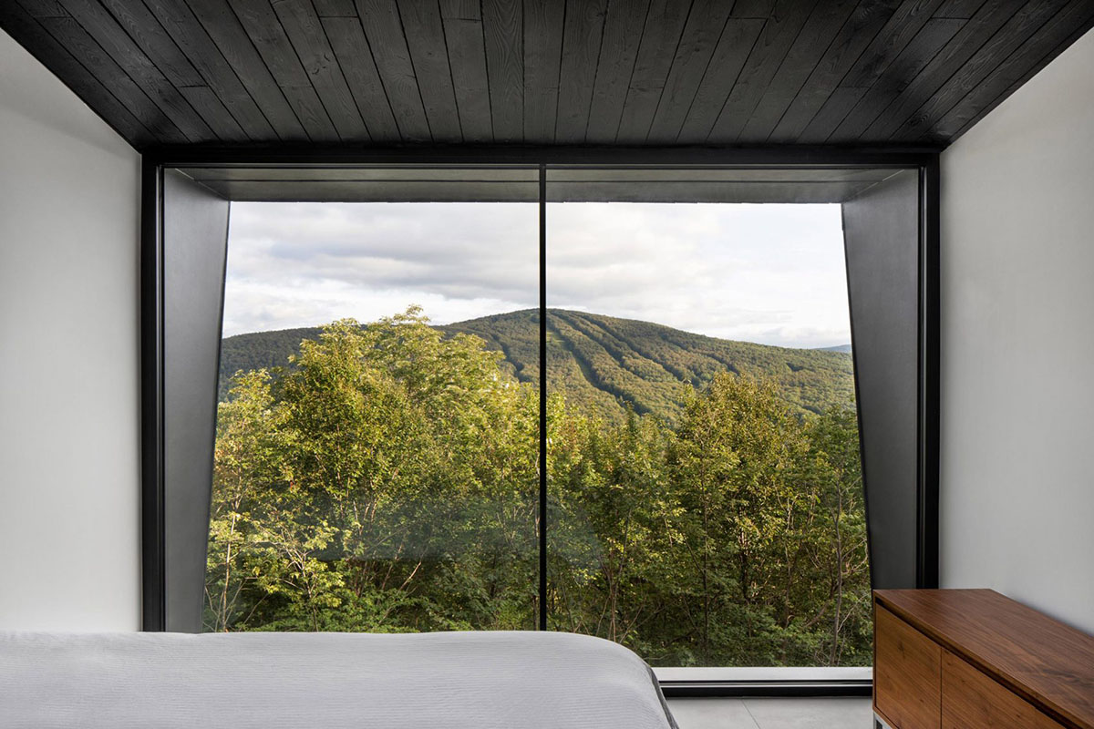 Two black wooden holiday cabins by Naturehumaine perched on a mountain of Quebec