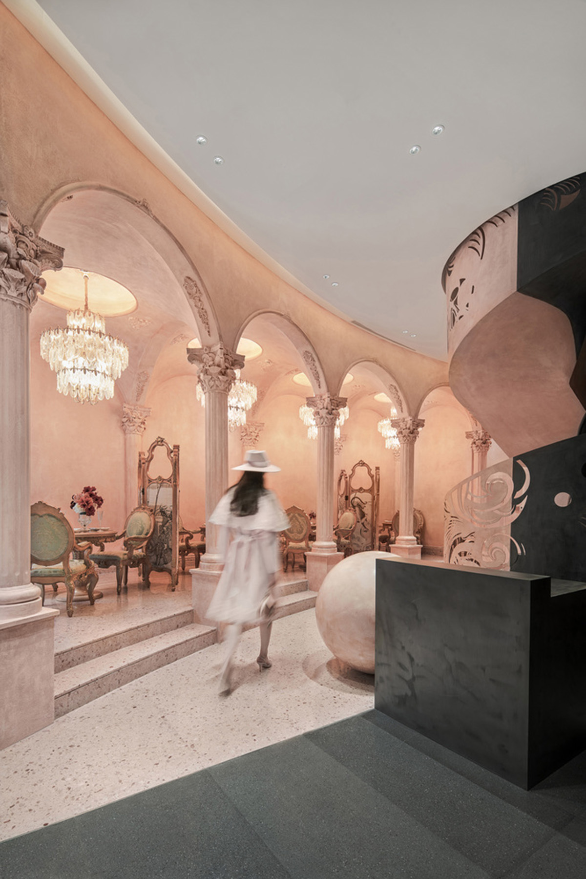 Pink elements and dark colors create sharp contrast in the interiors of restaurant and showroom