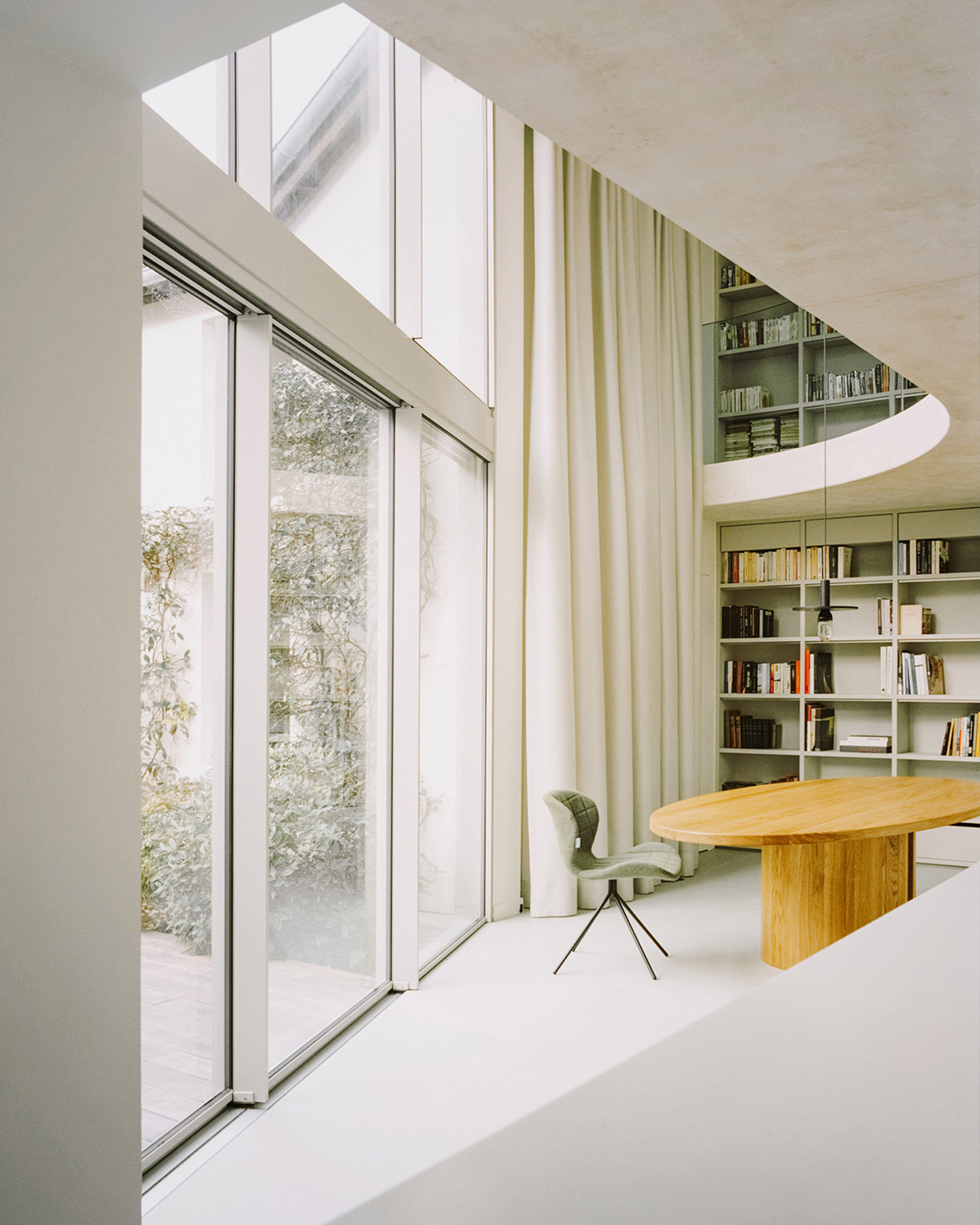 White concrete curved bridge gently complements interiors of The Island House in Paris