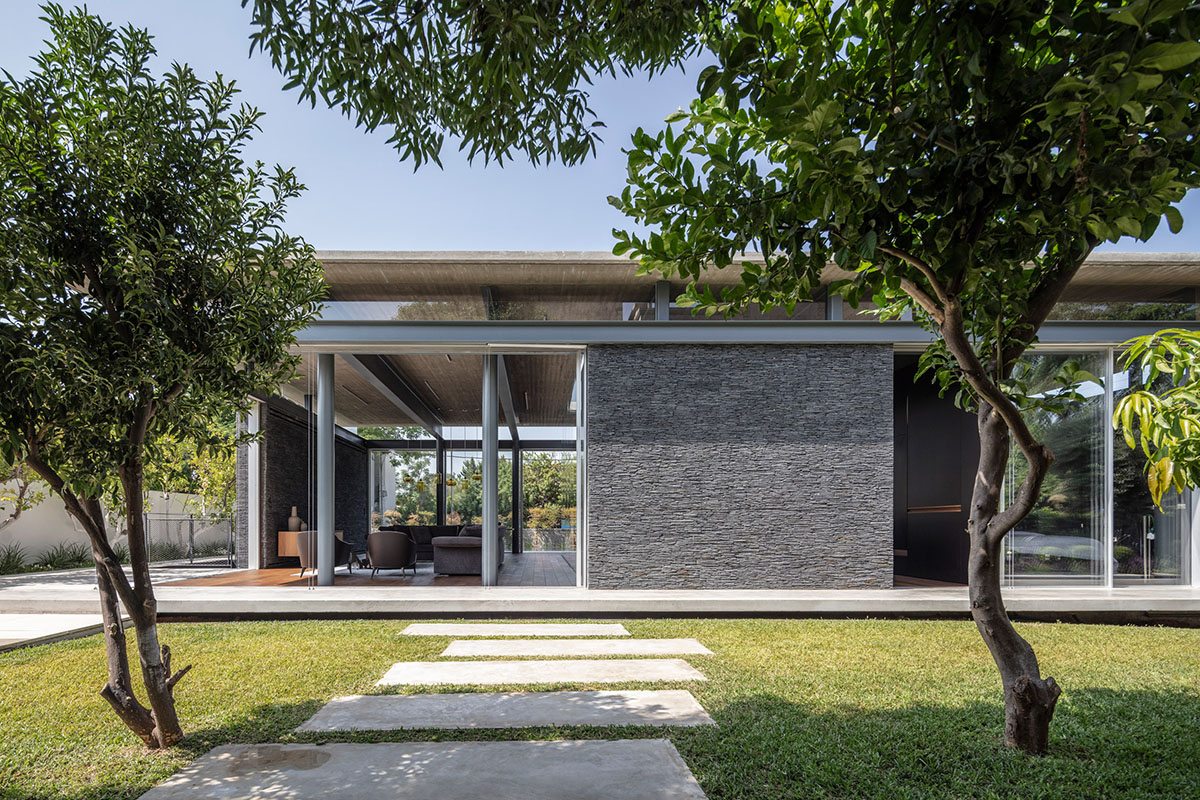 Pitsou Kedem Architects' black Pavilion House is reflected onto a linear swimming pool in Israel
