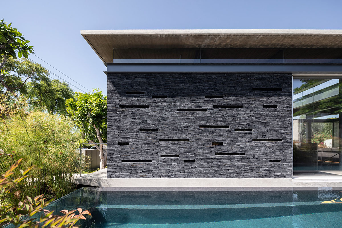 Pitsou Kedem Architects' black Pavilion House is reflected onto a linear swimming pool in Israel