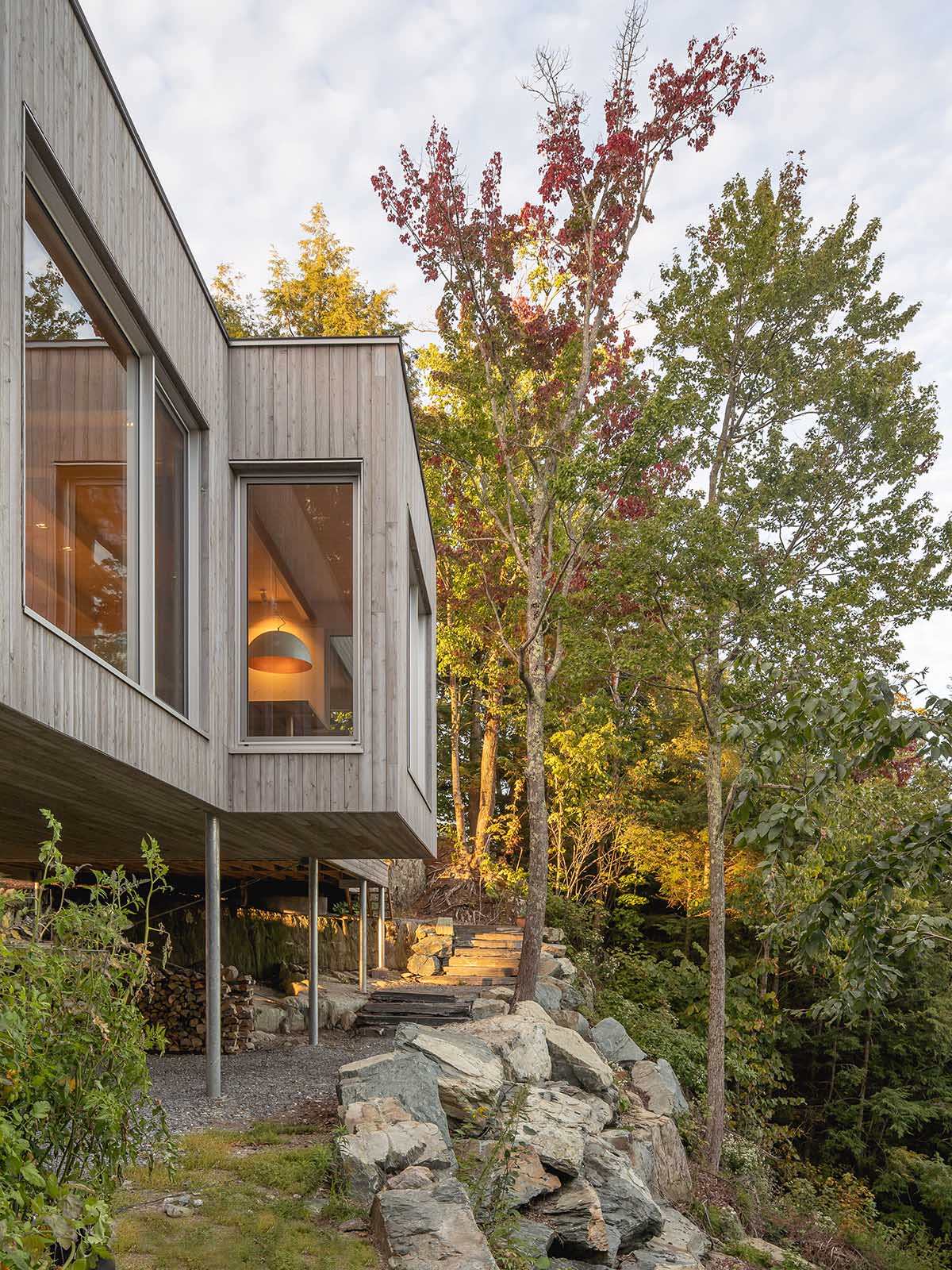 Natalie Dionne Architecture built wooden house raised on colums on a rocky landscape in Canada