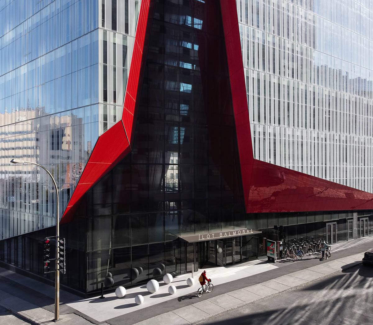 Provencher_Roy carves mixed-use office tower in Montréal with a red-colored diagonal slit