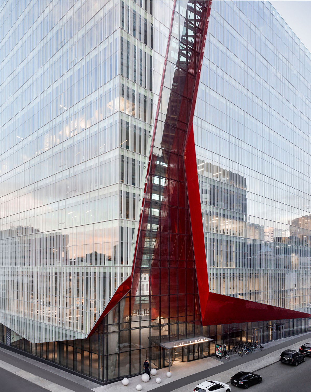 Provencher_Roy carves mixed-use office tower in Montréal with a red-colored diagonal slit
