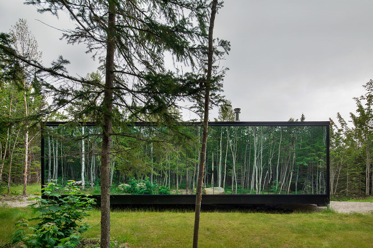 Bourgeois / Lechasseur architects built black wooden holiday cabin with mirrored façade in Québec