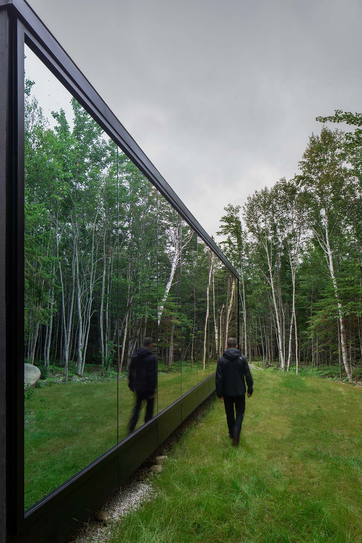 Bourgeois / Lechasseur architects built black wooden holiday cabin with mirrored façade in Québec