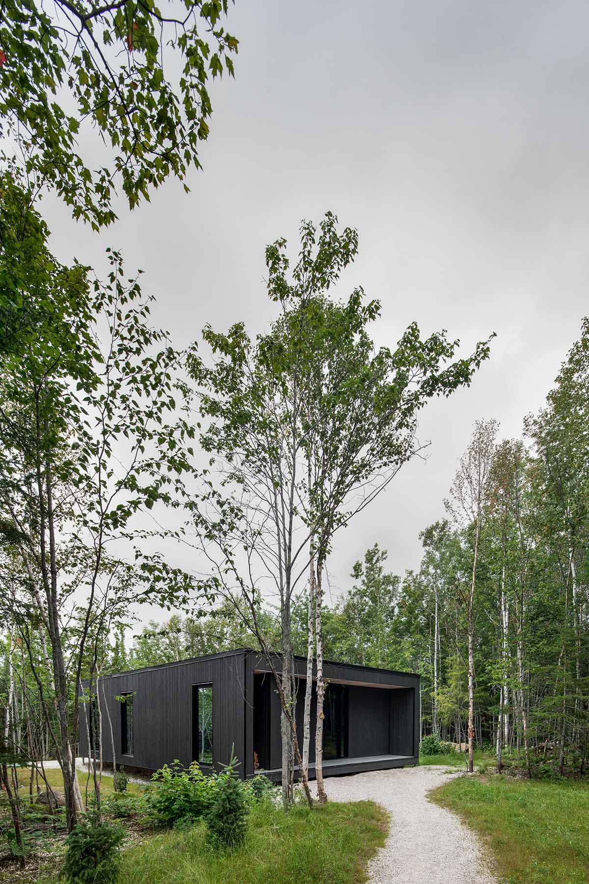 Bourgeois / Lechasseur architects built black wooden holiday cabin with mirrored façade in Québec