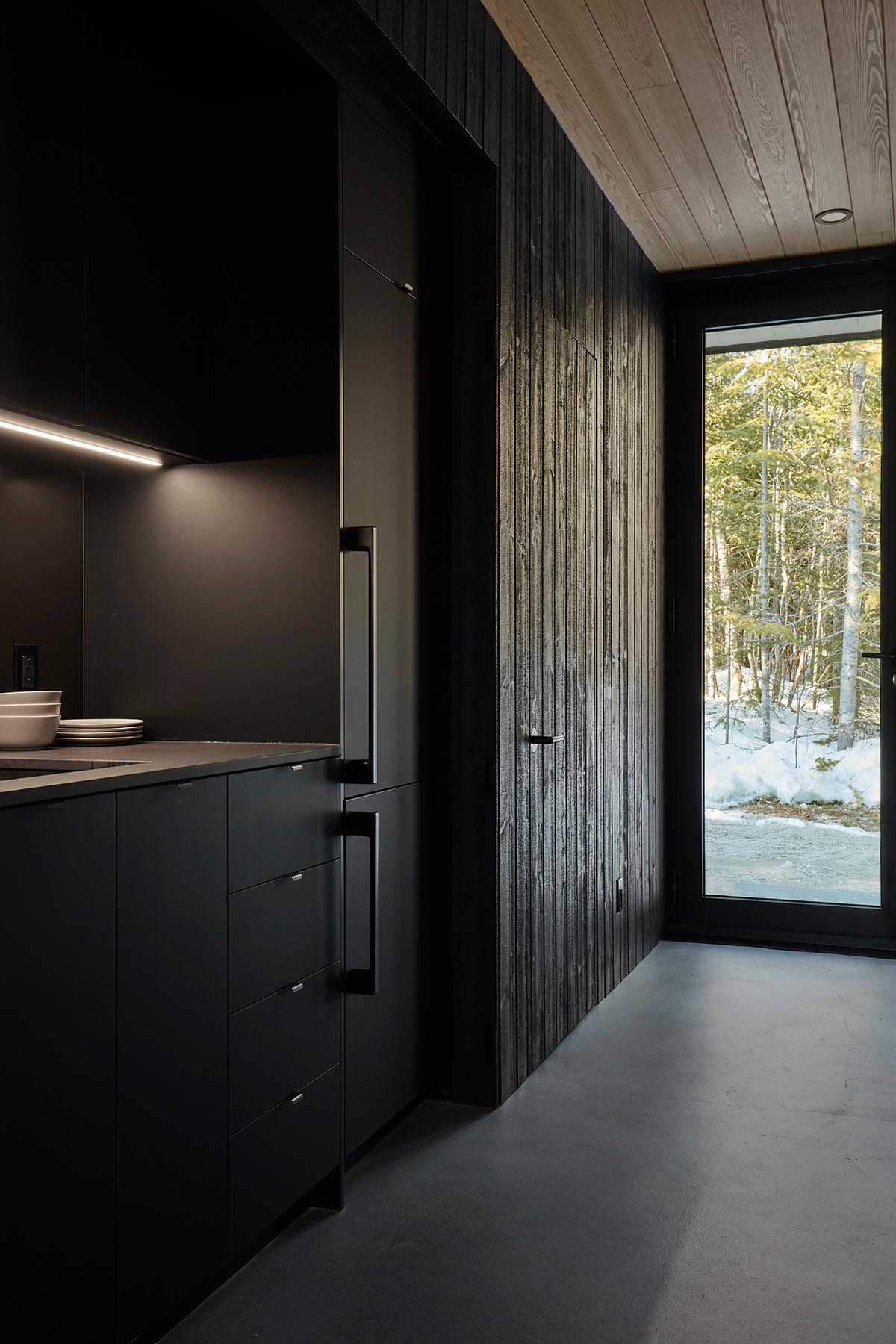 Bourgeois / Lechasseur architects built black wooden holiday cabin with mirrored façade in Québec
