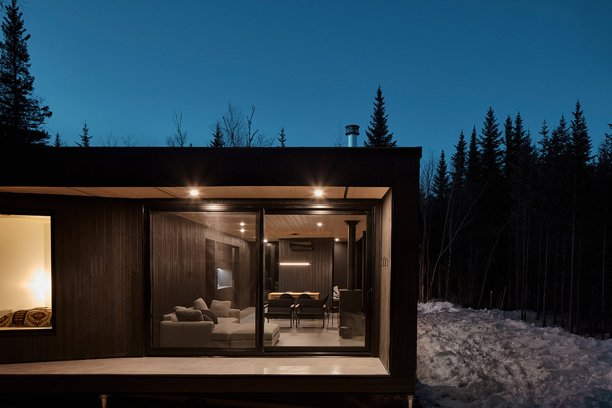 Bourgeois / Lechasseur architects built black wooden holiday cabin with mirrored façade in Québec