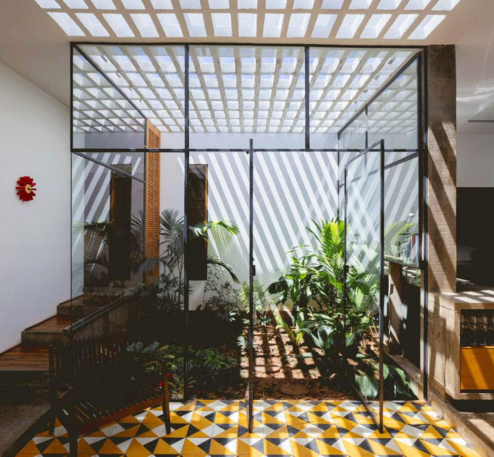 V&atilde;o designed recessed volumes and leaning red wall to offer flexible spaces for this Brazilian house