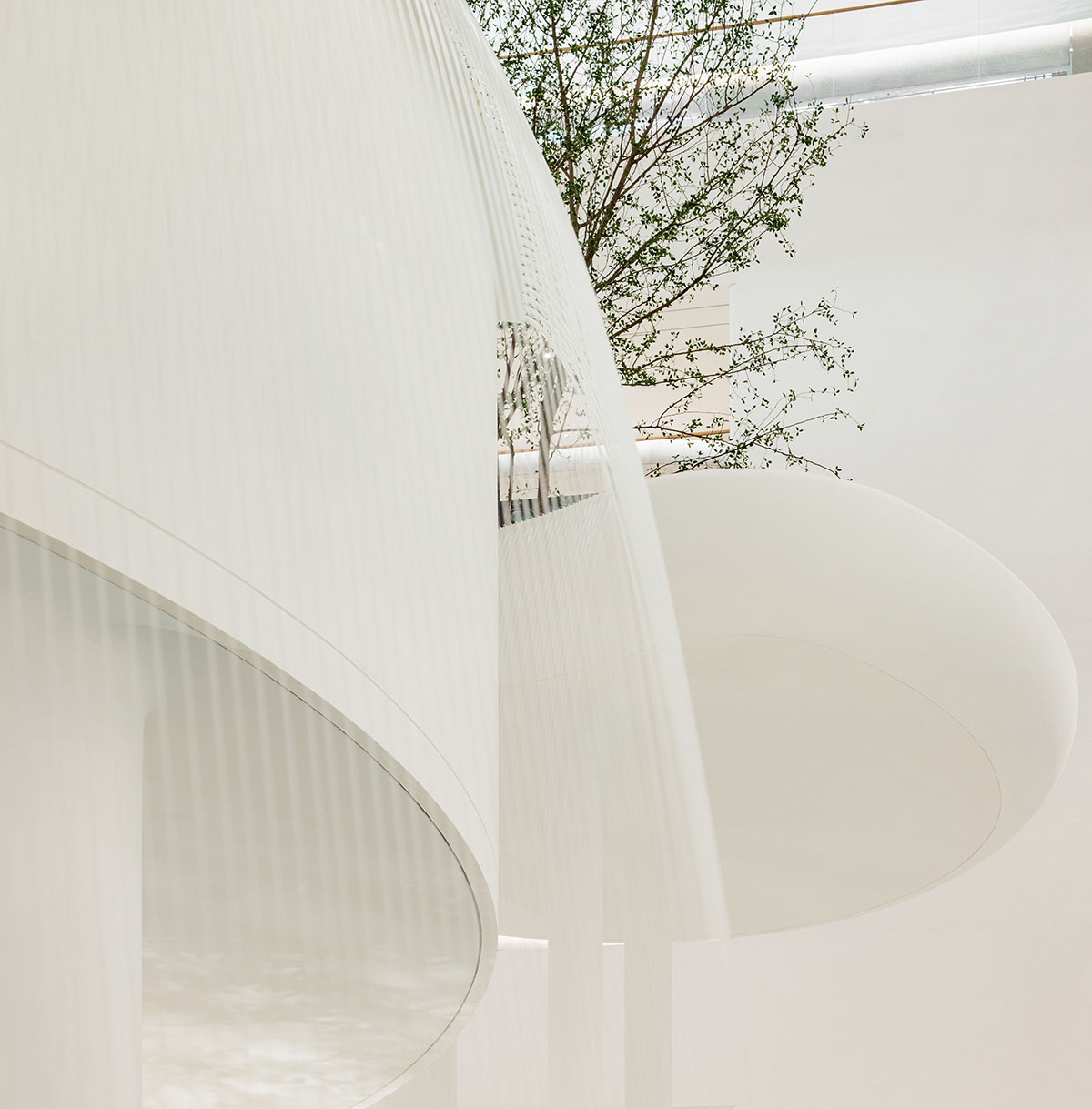 Burdifilek designs gallery-like interiors spaces featuring metallic surfaces and fluid forms