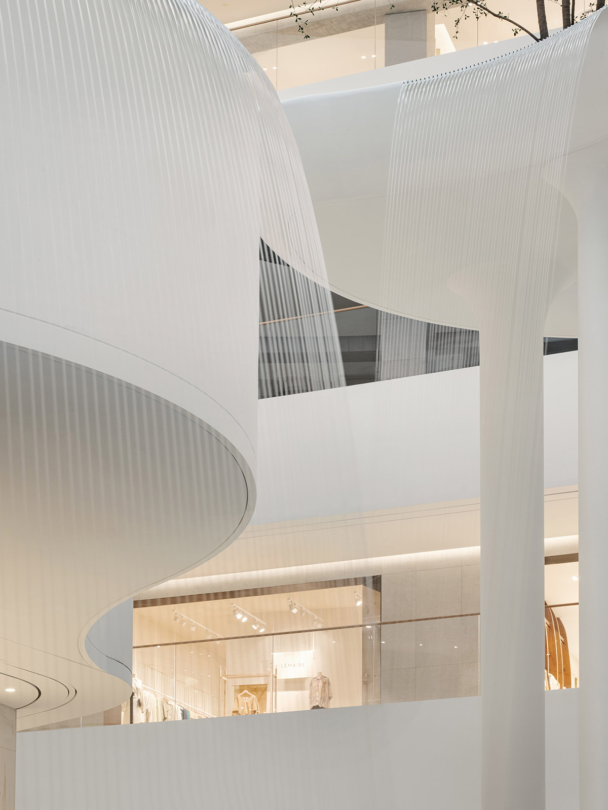 Burdifilek designs gallery-like interiors spaces featuring metallic surfaces and fluid forms