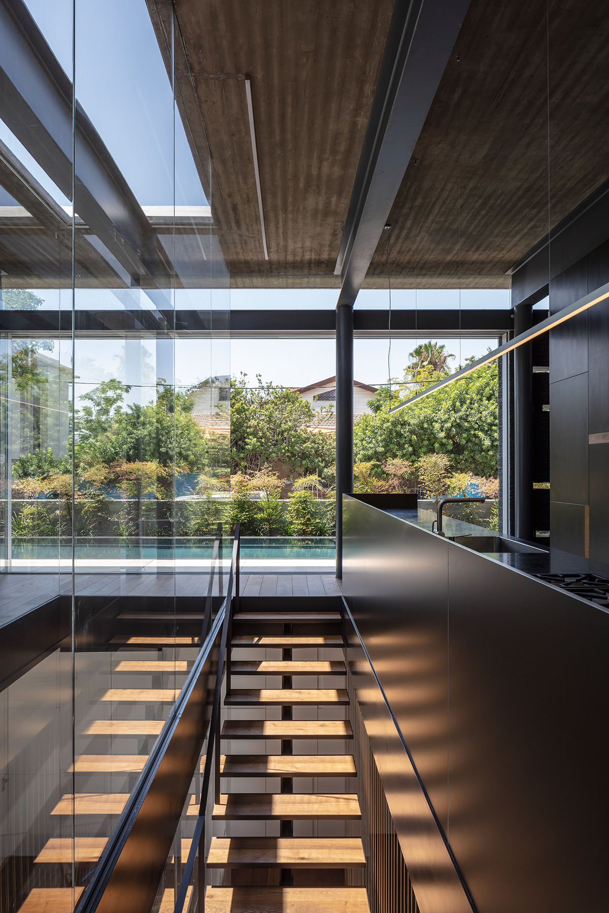 Pitsou Kedem Architects' black Pavilion House is reflected onto a linear swimming pool in Israel