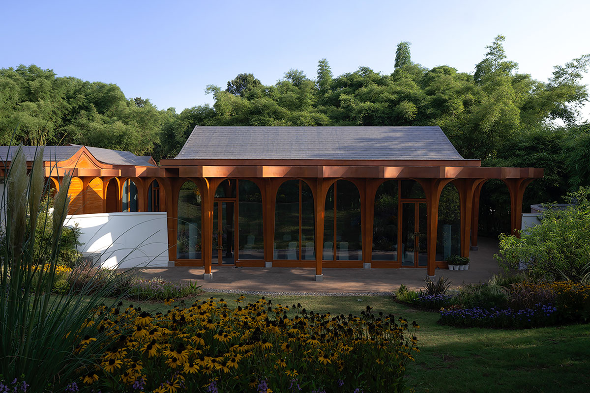 aoe designs Chinese Cultural Hall with cross-shaped arch columns nestled in a bamboo forest