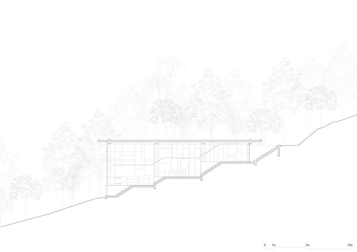 Two bold concrete platforms define this transparent library house by Atelier Branco Arquitetura