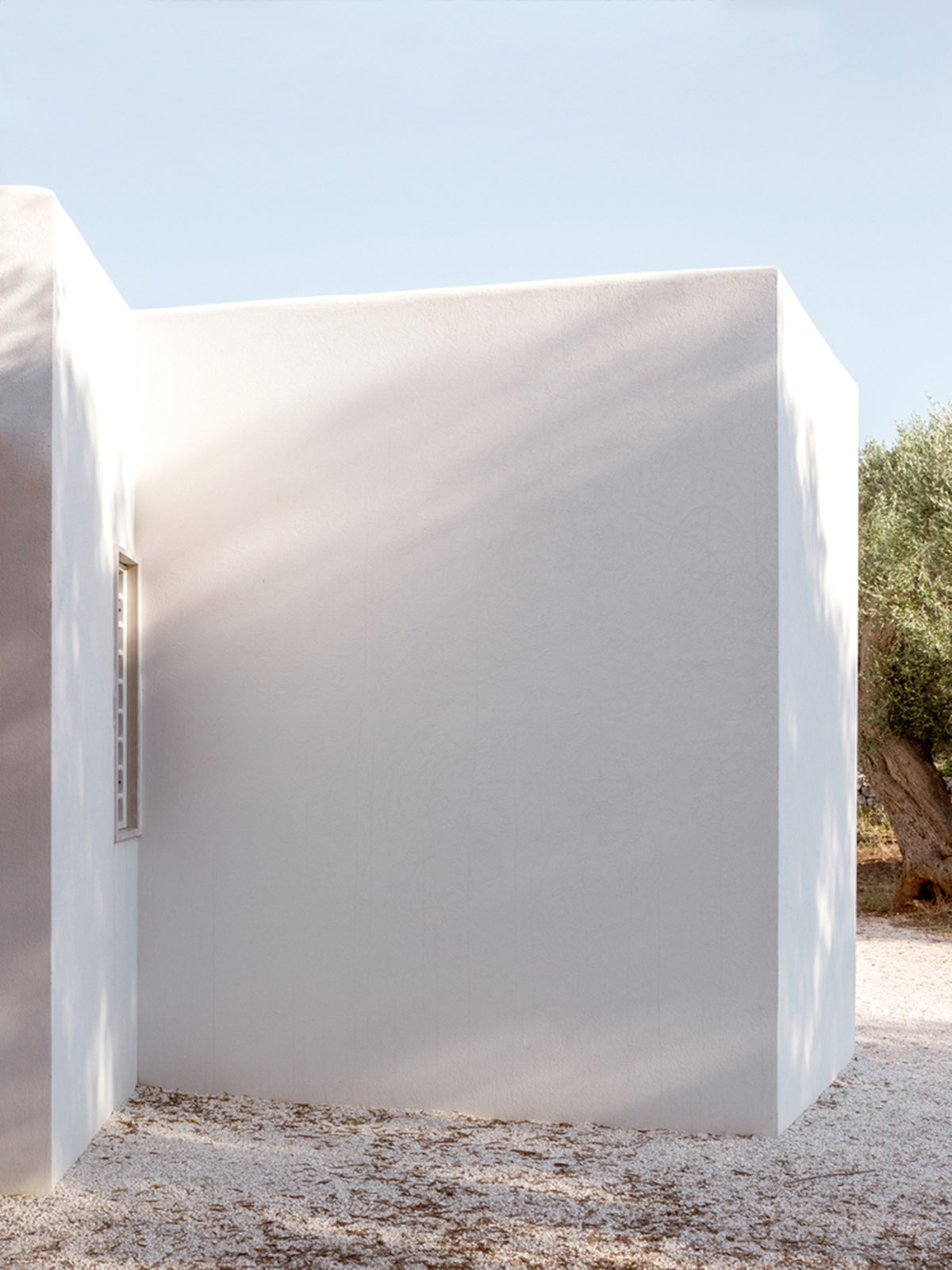 Noname Studio designs townhouse with all-white abstract sculpted volumes among olive trees