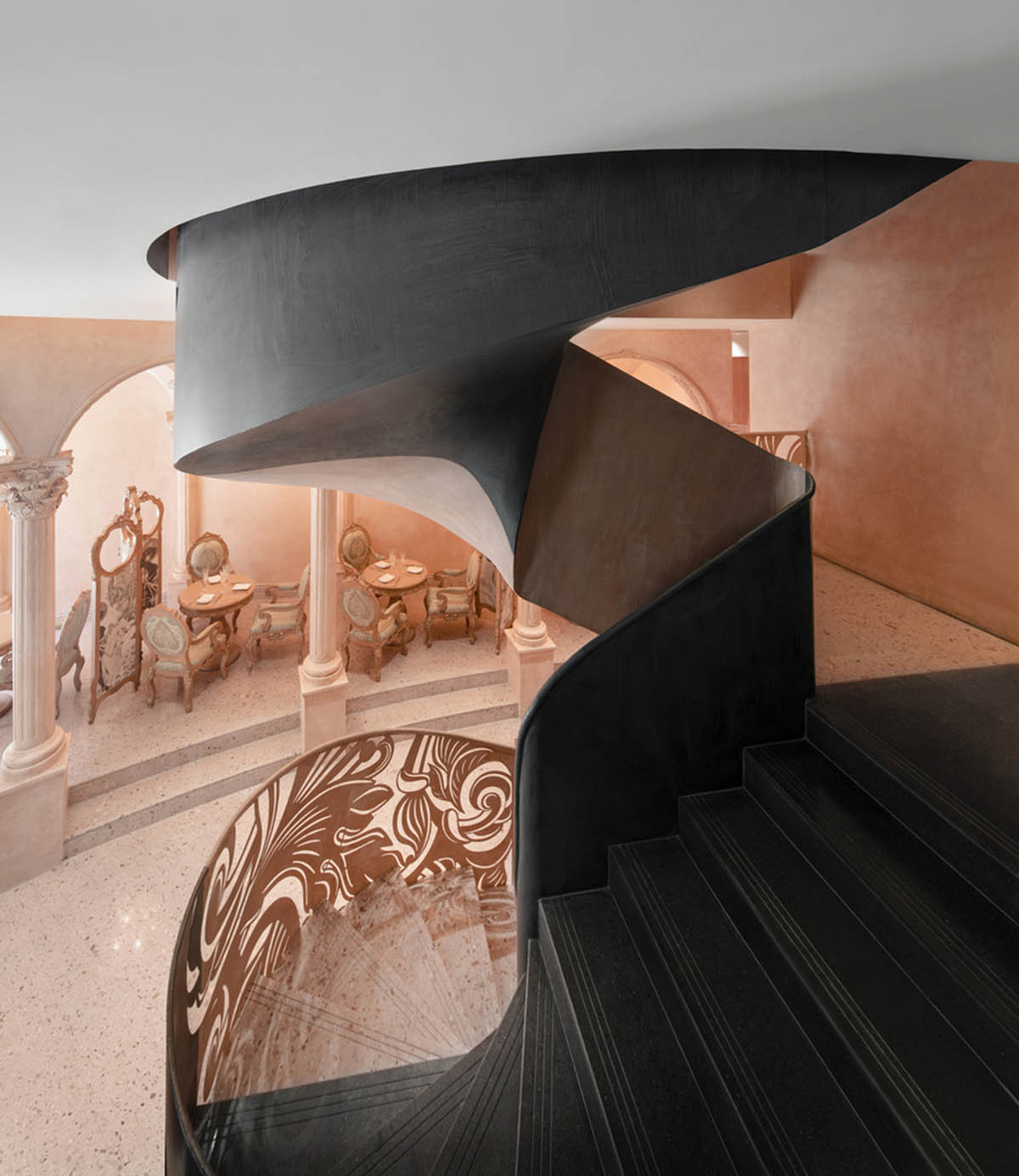 Pink elements and dark colors create sharp contrast in the interiors of restaurant and showroom