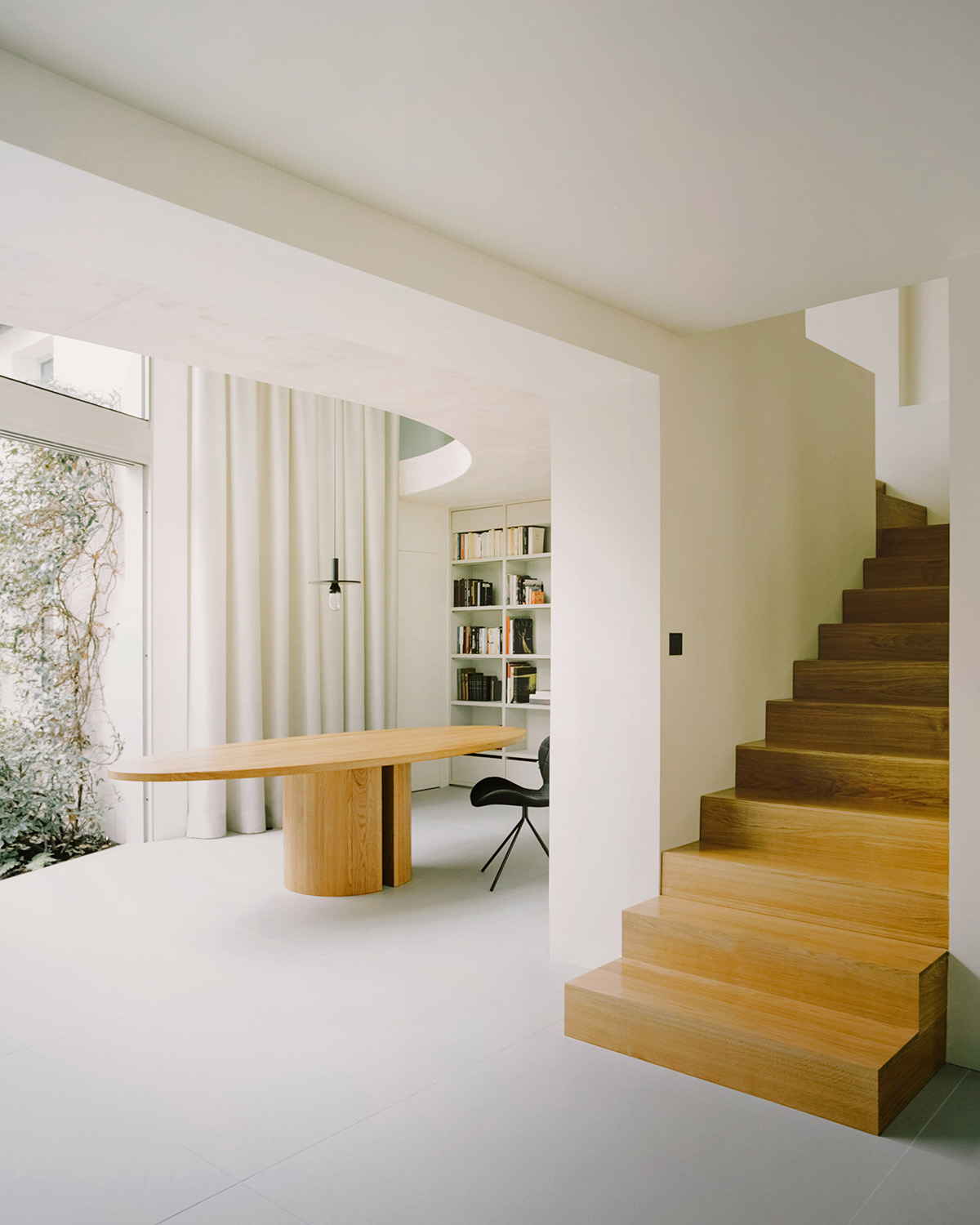 White concrete curved bridge gently complements interiors of The Island House in Paris