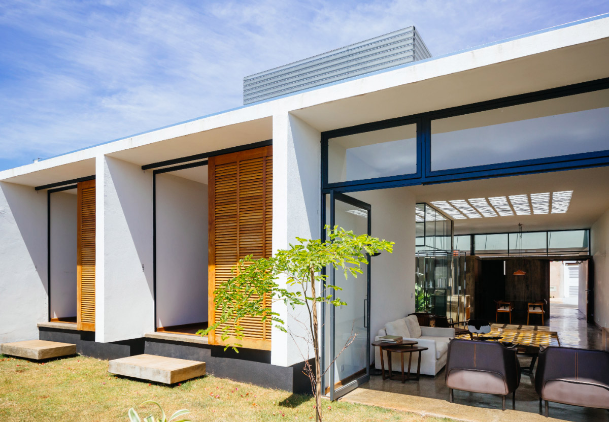 V&atilde;o designed recessed volumes and leaning red wall to offer flexible spaces for this Brazilian house